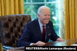 Presiden Joe Biden tersenyum setelah menandatangani perintah eksekutif yang memperkuat akses ke perawatan kesehatan yang terjangkau. (Foto: Reuters/Kevin Lamarque)