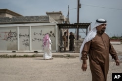 FILE - Residents visit the Kurdish Regional Government (KRG) headquarters in Rabia, northwestern Iraq, April 9, 2016. Critics say that for the KRG, everything is about internal Kurdish politics - even the fight against Islamic State is secondary to maintaining the upper hand politically.