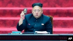 FILE - North Korean leader Kim Jong Un holds up a parliament membership certificate during the Supreme People's Assembly in Pyongyang, North Korea, April 9, 2014.