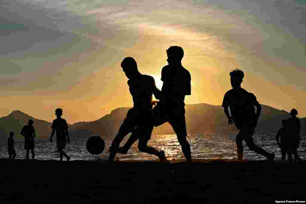 Youths play soccer along a beach as the sun sets in Banda Aceh, Indonesia.