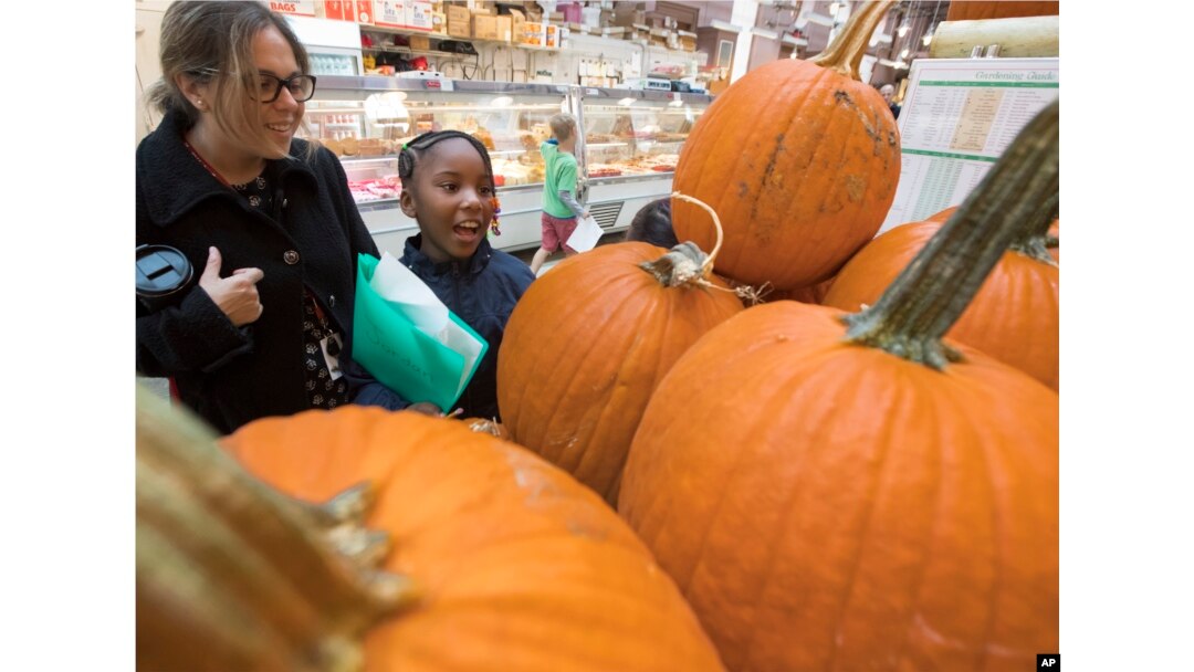Para siswa dan guru dari Mundo Verde Bilingual Public Charter School di Washington memperhatikan labu-labu dan produk lainnya dalam kunjungan ke Pasar timur di ibu kota, 13 Oktober 2017.