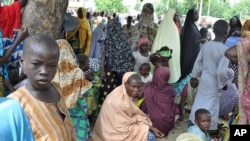 FILE - Civilians fleeing Islamist militants in the town of Bama take refuge at a school in Maiduguri. Nigeria's military says it has retaken Bama from Boko Haram.