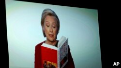 Hillary Clinton seen on a monitor at the Grammy Awards reading from the book, "Fire and Fury."