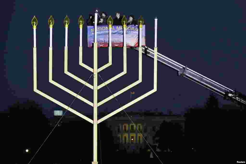 Rabbi Levi Shemtov (2nd L), executive vice president of American Friends of Lubavitch (Chabad), lights the U.S. National Chanukah (Hanukkah) Menorah on the Ellipse in front of the White House, Washington, D.C., with U.S. Trade Representative Michael Froman (2nd R) and Rabbi Abraham Shemtov (R), national director of American Friends of Lubavitch (Chabad), Nov. 27, 2013.