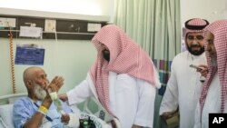 Sheikh Abdul Rahman Al Sudais, the imam of the Grand Mosque in Mecca, talks to one of the injured in the Sept. 11, 2015 crane accident at the mosque, at a hospital in Mecca, Saudi Arabia, Sept. 13, 2015.