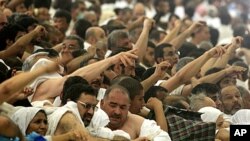 Muslim pilgrims cast stones at a pillar, symbolizing the stoning of Satan, in a ritual called "Jamarat," the last rite of the annual hajj, in Mina near the Saudi holy city of Mecca, Saudi Arabia, Nov. 6, 2011.