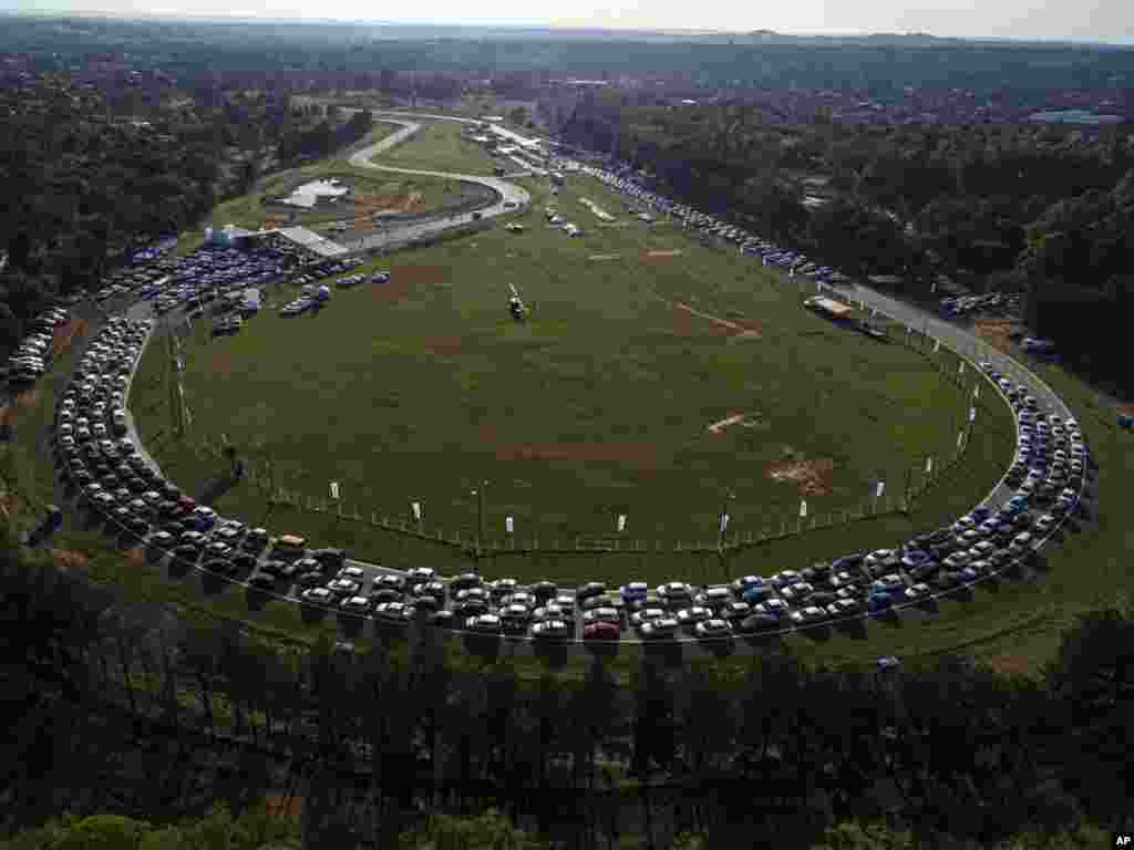 People line up at a drive-thru vaccination center at the Ruben Dumot Autodrome for Pfizer&#39;s COVID-19 vaccine in Capiata, Paraguay.