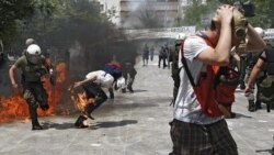 Riot police and demonstrators clash Tuesday during protests against austerity measures in Athens