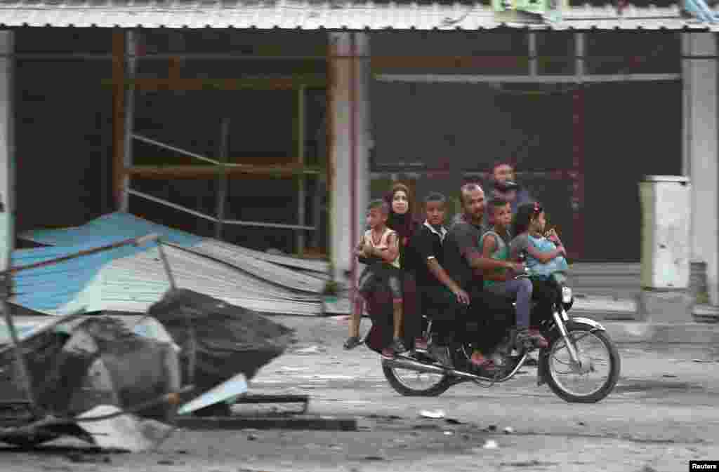 Members of a family ride on a motorcycle as they flee an area in the northeastern city of Hasaka, Syria, Aug. 20, 2016.