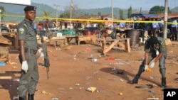 Police collect items at the site of a bomb explosion in Nyanya outskirt of Abuja, Nigeria, Oct. 3, 2015. 