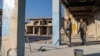 FILE - People repaint a part of their home that was damaged during the war during the Assad regime, in Saraqib, on the outskirts of Idlib, Syria, Jan. 15, 2025. 