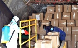 A member of a medical team wearing protective suits sanitizes cargo that arrived inside a plane at the airfield to prevent the spread of COVID-19 at the Juba International Airport in Juba, South Sudan, April 5, 2020.