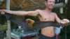 FILE - A rice soup vendor shows a giant bat to his customers at his small restaurant in the suburb of Chroy Ampil district, 15 kilometers east of Phnom Penh, Saturday, August 24, 1996. 