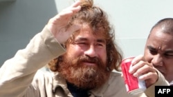 Mexican castaway who identified himself as Jose Ivan and later told that his full name is Jose Salvador Alvarenga walks with the help of a Majuro Hospital nurse in Majuro after a 22-hour boat ride from isolated Ebon Atoll, Feb. 3, 2014. 