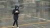 A woman crosses a deserted street in Melbourne's central business district on August 19, 2020, as the city battles an outbreak of the COVID-19 coronavirus. - Australia should make any coronavirus vaccine compulsory for its 25 million citizens bar…