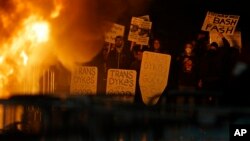 Protestors watch a fire on Sproul Plaza during a rally against the scheduled speaking appearance by Breitbart News editor Milo Yiannopoulos on the University of California at Berkeley campus, Feb. 1, 2017, in Berkeley, Calif.