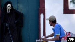 فبیو د آلمیدا، بازیگر برزیلی، با پوشیدن لباسی که یادآور مرگ است، در خیابان‌‌های برزیل حضور پیدا کرده تا مردم را از خطر همه‌گیری کرونا و اهمیت پوشیدن ماسک آگاه کند - فورمیگا، برزیل، ۷ اوت ۲۰۲۰