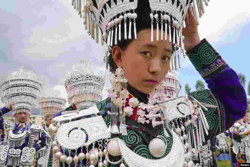 Yi ethnic minority girls wait to participate in a traditional performance to celebrate the Torch Festival in Butuo County, Sichuan province, China.