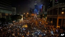 Tens of thousands of pro-democracy demonstrators, some waving lights from mobile phones, fill the streets in the main financial district of Hong Kong, Oct. 1, 2014.