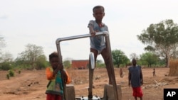 Children play on a water pump in an internally displaced camp in Gaoa, Burkina Faso, April 22, 2021.