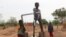 Children play on a water pump in an internally displaced camp in Gaoa, Burkina Faso, April 22, 2021.