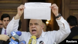 Jesus Torrealba, le secrétaire de la coalition des partis de l'opposition du Venezuela (MUD), montre une copie du formulaire pour recueillir les signatures du lancement d'un référendum censé éliminer le président Nicolas Maduro. C’est à l’occasion d'une conférence de nouvelles à Caracas, au Venezuela, le 26 Avril 2016. (REUTERS/Marco Bello - RTX2BSRM)