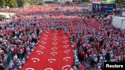 Thousands of demonstrators carry Turkey's national flags during a march protesting recent Kurdish militant attacks on Turkish security forces, in Ankara, Turkey, Sept. 17, 2015. 