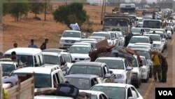 Largas filas de vehículos se alinean para tratar de escapar de Sirte, los cuales son inspeccionados por las fuerzas rebeldes.