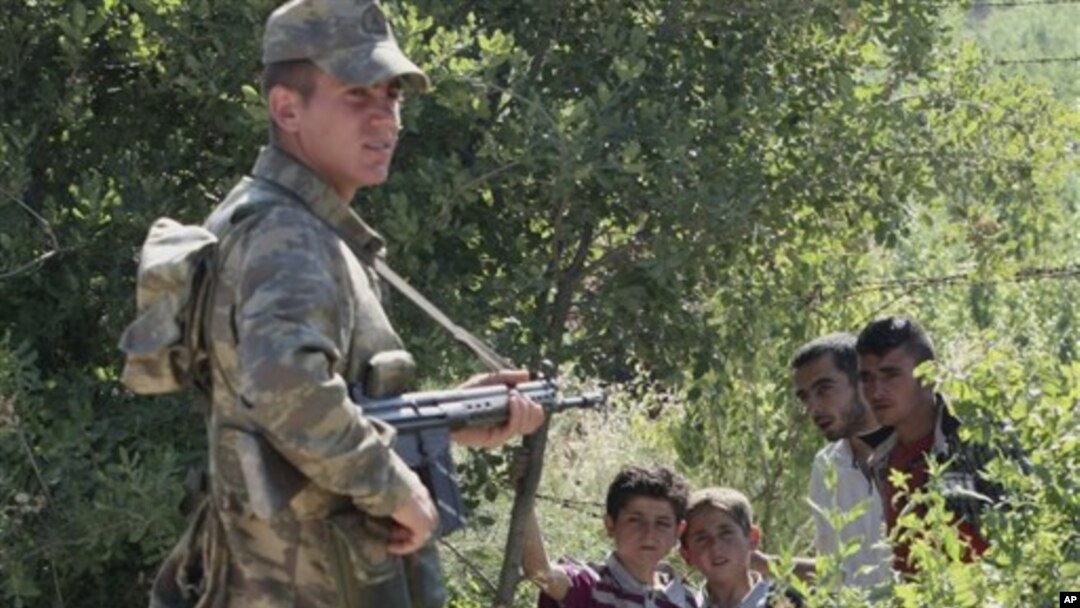 Turk chegarachisi va suriyaliklar, Suriya bilan chegaradosh Xatay viloyati, 9-iyun, 2011-yil.