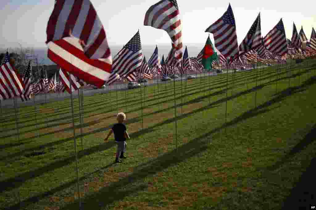 Seorang bocah cilik berlari di antara bendera-bendera Amerika yang berkibat di Universitas Pepperdine di Malibu, California (10/9).