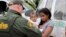 A mother migrating from Honduras holds her 1-year-old child as she surrenders to U.S. Border Patrol agents after illegally crossing the border near McAllen, Texas, June 25, 2018.