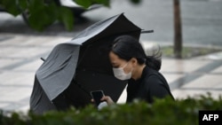 A woman holding her umbrella walks in strong winds in Seoul, South Korea, on Aug. 27, 2020, after Typhoon Bavi hit the Korean Peninsula. 