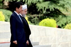 Iranian President Hassan Rouhani, right, welcomes Japanese Prime Minister Shinzo Abe, during a welcoming ceremony at the Saadabad Palace in the capital Tehran, June 12, 2019.