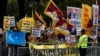 FILE - A man waves a Uyghur flag amongst pro-Tibet supporters as they demonstrate against China's President Xi Jinping outside Downing Street in central London, Britain, Oct. 21, 2015.