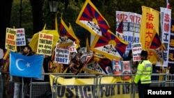 FILE - A man waves a Uyghur flag amongst pro-Tibet supporters as they demonstrate against China's President Xi Jinping outside Downing Street in central London, Britain, Oct. 21, 2015.