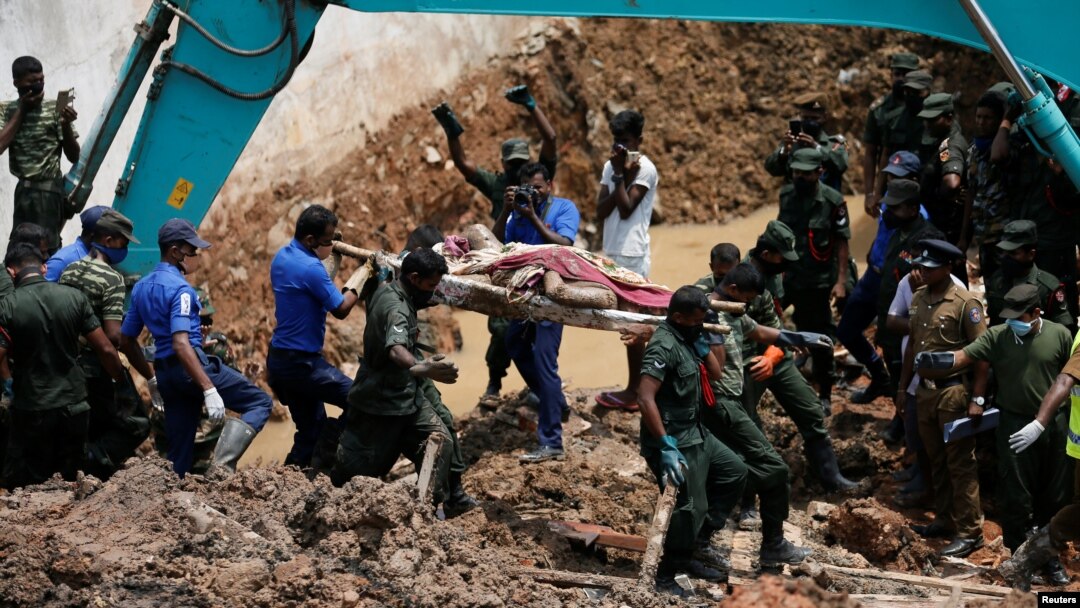 Anggota militer Sri Lanka mengangkut jenazah korban tewas akibat tertimbun sampah longsor di pinggiran Kolombo, Sri Lanka, Minggu (16/4).