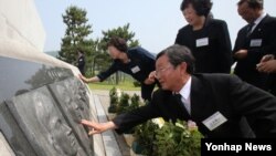 29일 제2 연평해전 전사자 유가족들이 기념비에 새겨진 전사자의 얼굴을 어루만지고 있다.