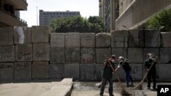 Egyptian street cleaners clean up the area around the U.S. embassy in Cairo, Egypt, Saturday, Sept. 15, 2012.