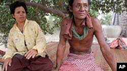 Cambodian legs amputee Meo, right, 48, sits next to his wife at their home in Prey Tapork village, Kandal province, about 30 kilometers (18 miles) west of Phnom Penh, Cambodia, Sunday, March 29, 2009. Meo was amputee in 1994 in a strong hold while he was a soldier fighting with Khmer Rouge. On Monday, March 30, 2009, Kaing Guek Eav, also known as "Duch" will go on trial for crimes against humanity. "Duch" was commander of the Toul Sleng prison under the Khmer Rouge where thousands were tortured and killed. (AP Photo/Heng Sinith)