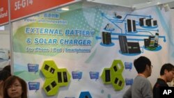 An advertisement shows solar batteries that are compatible with Apple products, like the iPhone and iPad, at the Hong Kong Electronics Fair, October 13, 2011.