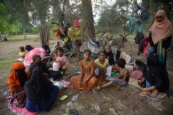 Rohingya Muslims rest on a beach after their boat was stranded on Idaman Island in East Aceh, Indonesia, June 4, 2021.