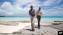 El presidente Barack Obama y el superintendente de Monumentos Marinos Nacionales, Matt Brown, caminan en Playa Tortuga, en atolón de Midway. 