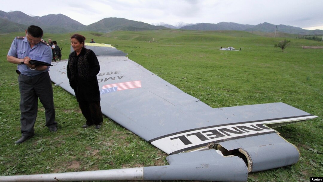 Seorang petugas tengah menanyai seorang penduduk yang berada di sekitar lokasi ditemukannya kepingan pesawat Boeing KC-135 Stratotanker, di desa Chaldovar, Kyrgyzstan (3/5). Pesawat militer AS tersebut jatuh hari Jumat (3/5), sekitar 160 kilometer dekat pangkalan udara AS, Bandara Internasional Manas, Kyrgyzstan .