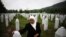 Mejra Dzogaz touches the graves of her two sons on May 17, 2012. Mejra's husband, three sons and a grandson were killed during the Srebrenica massacre in 1995 by a Serbian army unit commanded. 