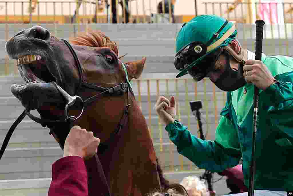 Jockey Cristian Demuro riding Sottsass celebrates after winning the Qatar Arc de Triomphe horse race at the Longchamp race track, outside Paris, France.