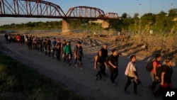 资料照片: 2023年9月23日德克萨斯州伊格尔帕斯: 从墨西哥穿越格兰德河进入美国的移民正在排队接受美国海关和边境保护局的处理