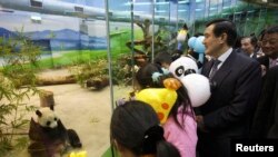 Presiden Taiwan saat itu, Ma Ying-jeou, didampingi oleh 500 orang yatim dan anak-anak dari keluarga miskin saat ia menengok Tuan Tuan dan Yuan Yuan dua panda raksasa hadiah dari China, di Kebun Binatang Kota Taipei, Muzha, 24 Januari 2009 (foto: Reuters/Guo Ru-hsiao/Pool)