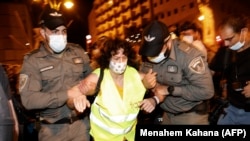 Des policiers israéliens retirent des manifestants de la rue près de la résidence du Premier ministre à Jérusalem, le 22 août 2020. (Photo by MENAHEM KAHANA / AFP)