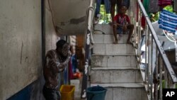 Una persona se baña en una escuela pública que sirve de refugio para personas desplazadas de sus hogares debido a enfrentamientos entre bandas armadas en Puerto Príncipe, Haití, el lunes 22 de abril de 2024.