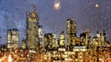 The buildings of the banking district are seen through thousands of rain drops on a glass railing in central Frankfurt, Germany.